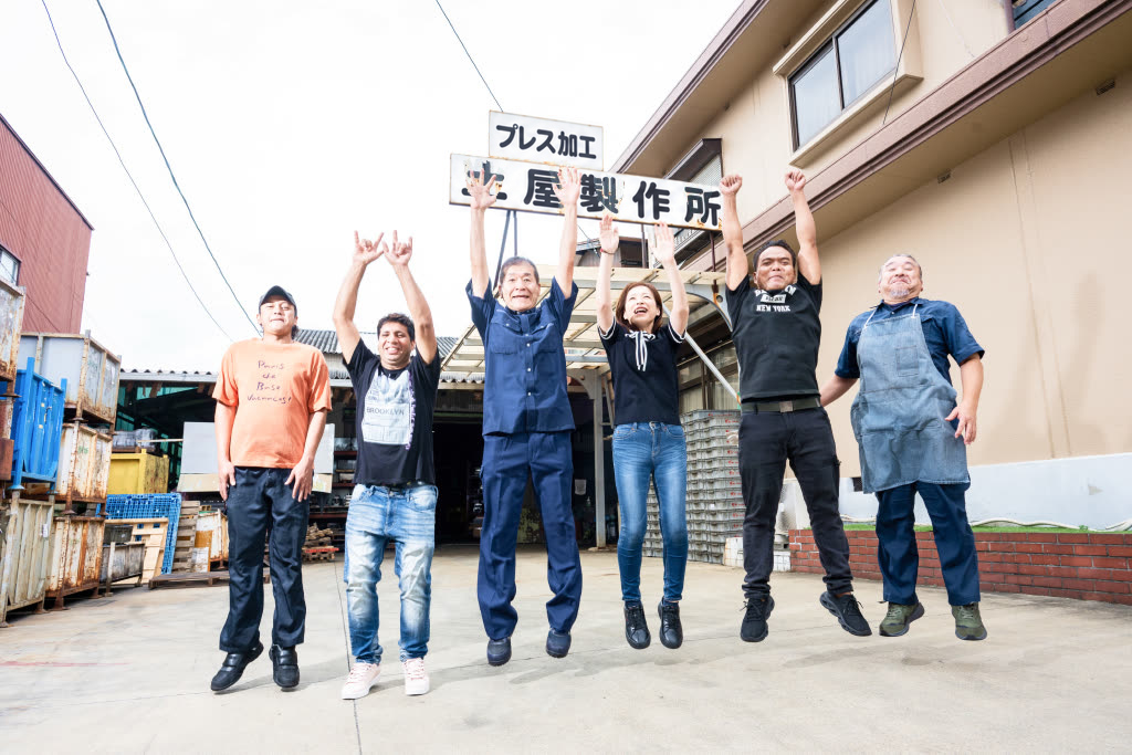 社屋前で万歳をする土屋製作所の社員